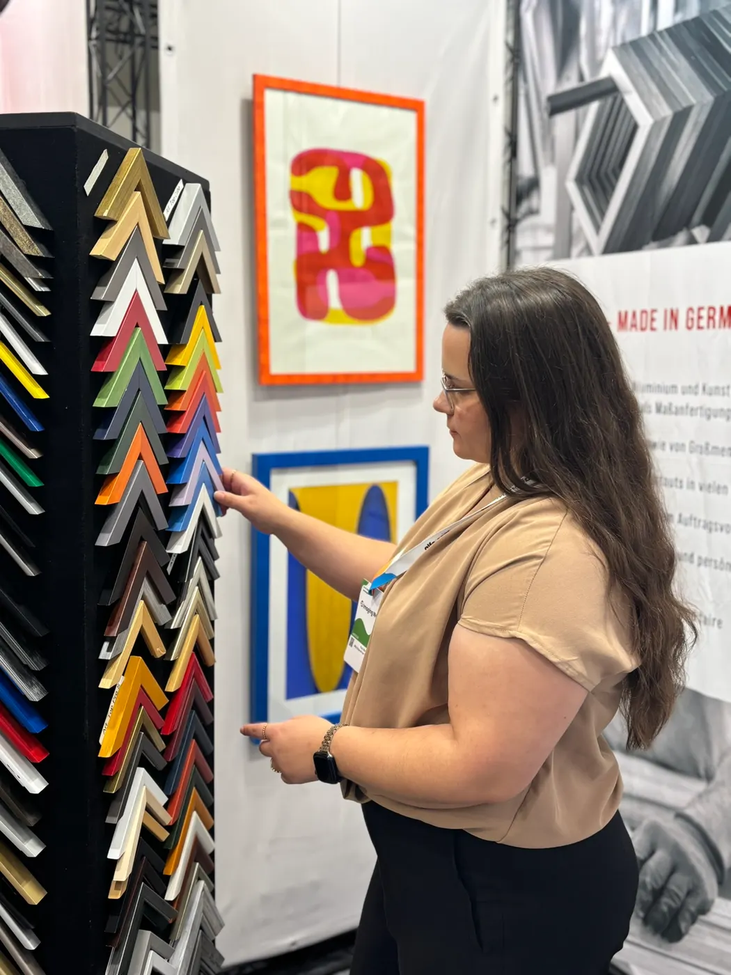 Torre de perfiles con muestras de esquinas y láminas artísticas enmarcadas en nuestro stand