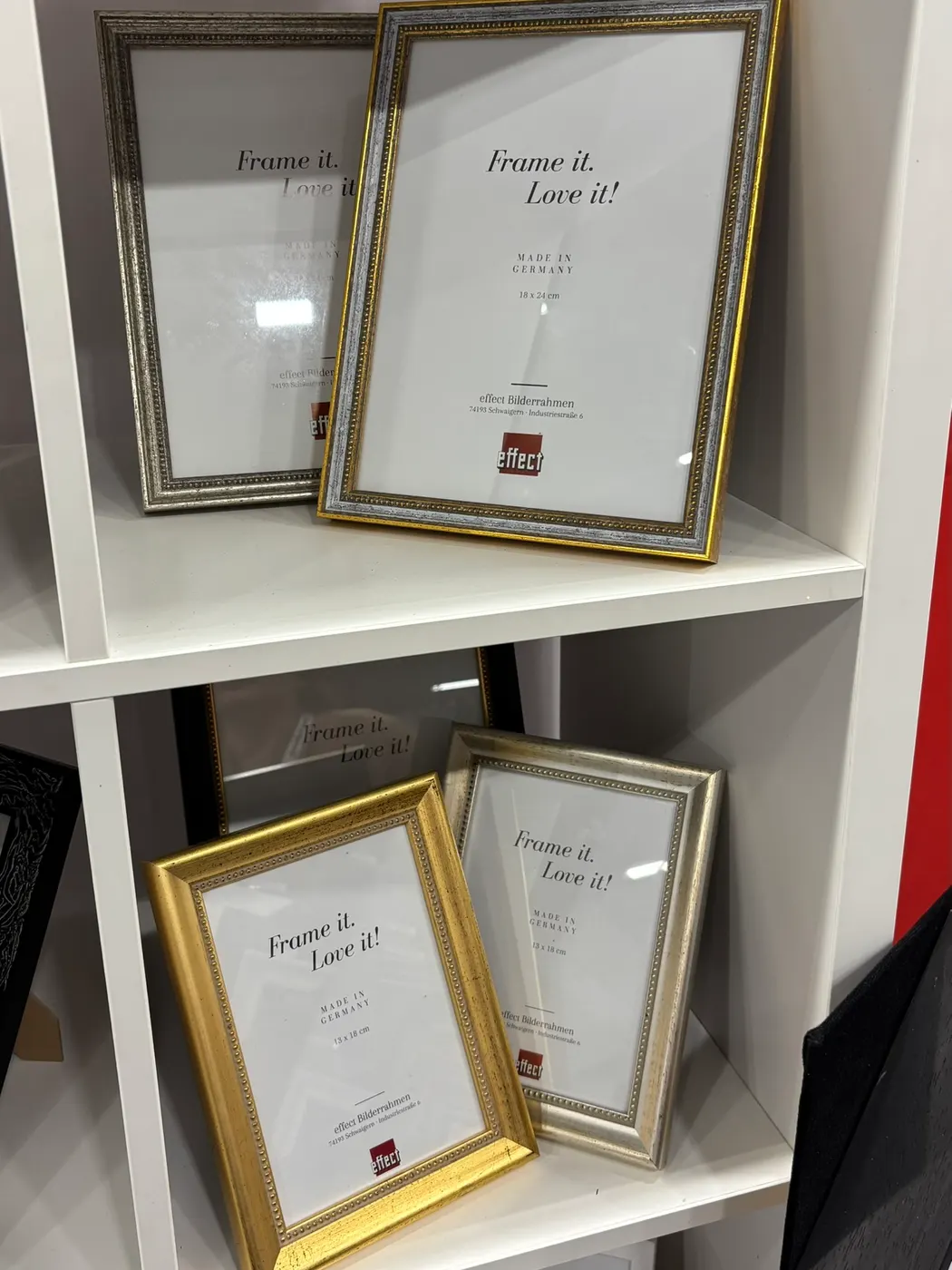 Marcos ornamentados en dorado y plateado en una estantería de nuestro stand