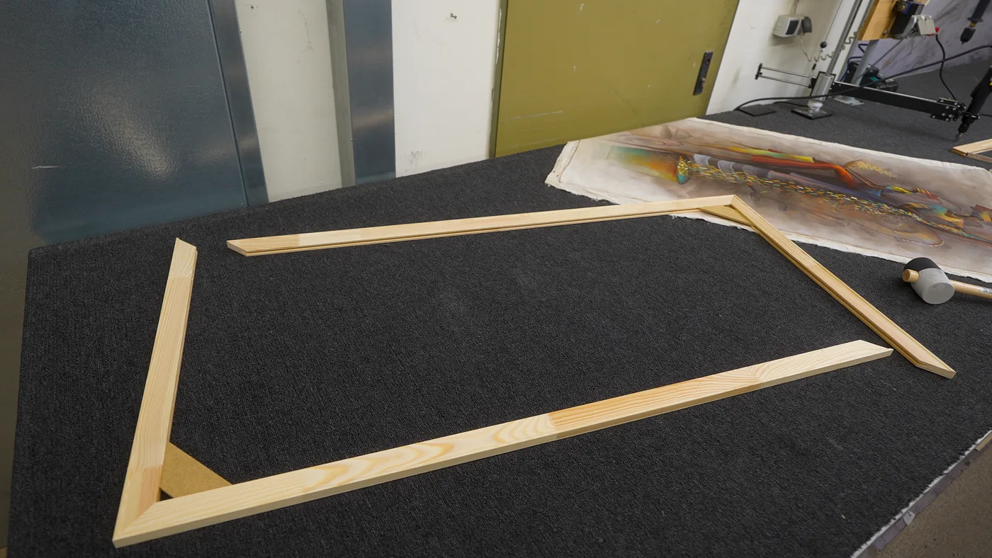 Dos formas en L montadas con listones de bastidor sobre la mesa de taller