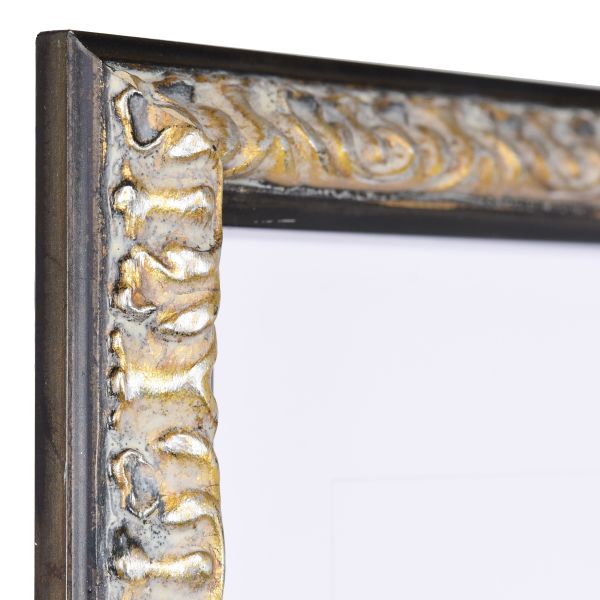 Vista de la esquina de un marco de madera barroco negro, con formas elaboradas y ornamentación floral