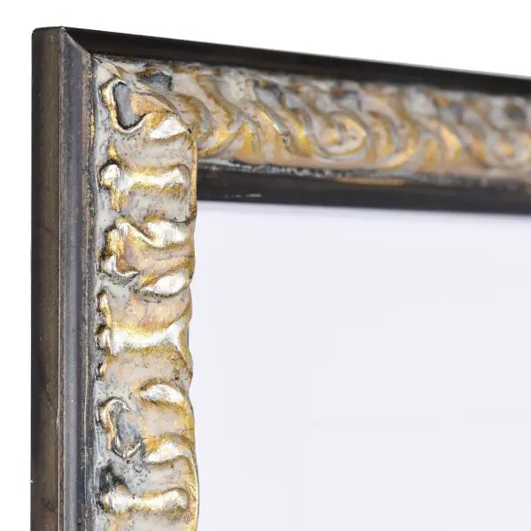 Vista de la esquina de un marco de madera barroco negro, con formas elaboradas y ornamentación floral