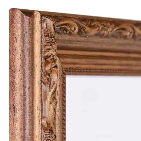 Vista de la esquina de un marco de madera marrón de estilo barroco con una superficie rústica teñida de nogal, ornamentos florales ligeramente brillantes y una moldura de perlas en el borde interior