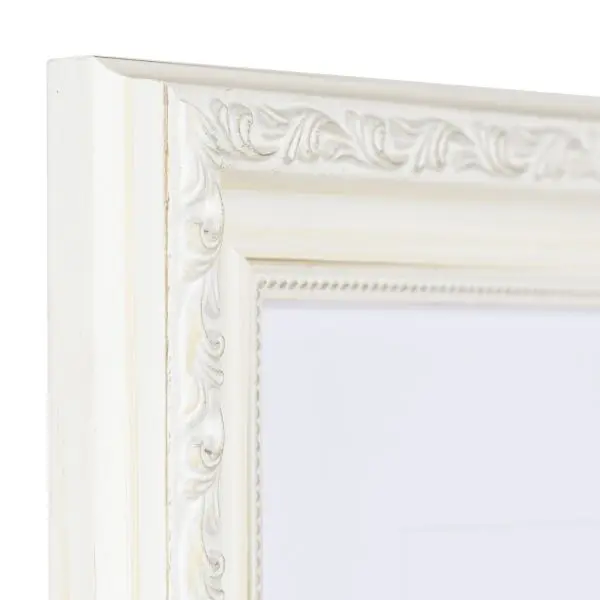 Vista de la esquina de un marco de madera barroco blanco y caprichoso con ornamentos florales y un delicado motivo de perlas