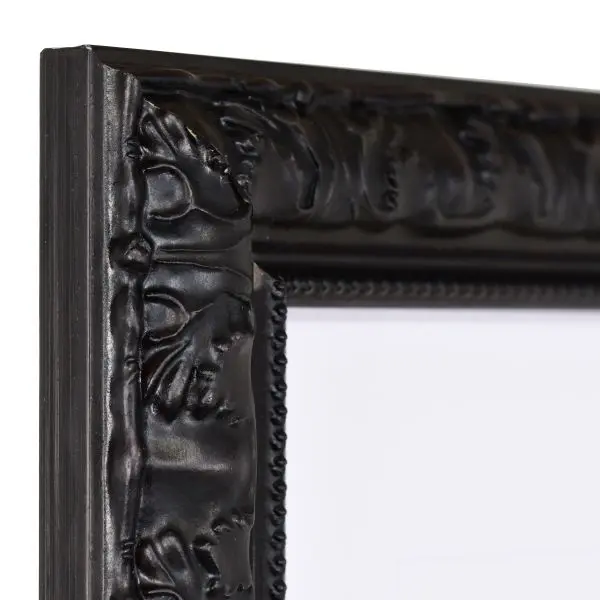 Vista de la esquina de un marco de madera negro con un diseño elegante y barroco y borde de perlas.