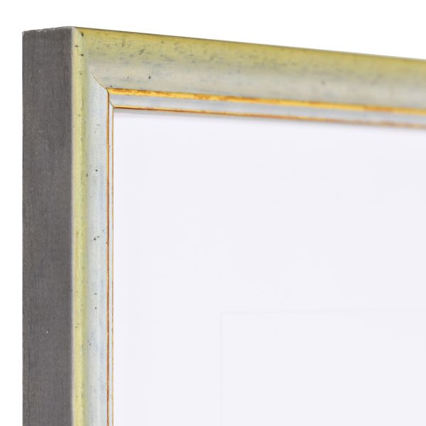 Vista de la esquina de un marco de madera vintage verde con superficie ligeramente rugosa y borde decorativo dorado