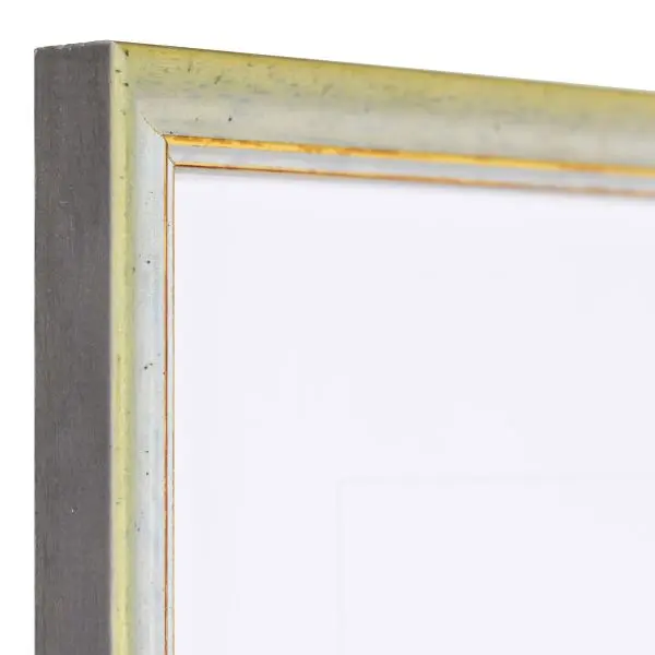 Vista de la esquina de un marco de madera vintage verde con superficie ligeramente rugosa y borde decorativo dorado
