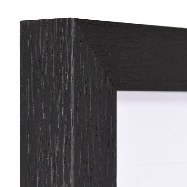 Vista de la esquina de un marco de madera negro, lacado de poro abierto con estructura de madera visible y palpable.