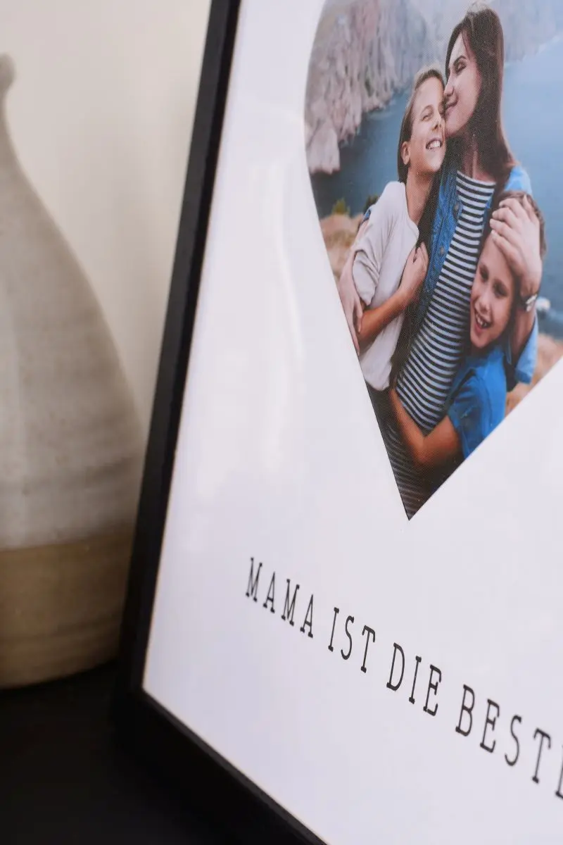 Primer plano de un marco de fotos de 30x30 en negro con paspartú de corazón para mamá