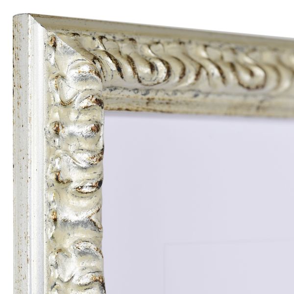 Vista de la esquina de un marco de madera barroco plateado, ricamente adornado con ornamentación floral