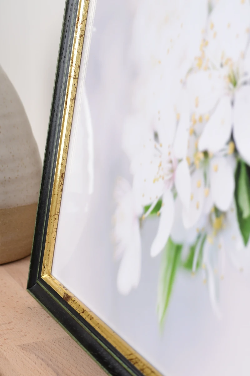 Primer plano del marco de fotos de madera Annelie en verde en un ambiente de salón