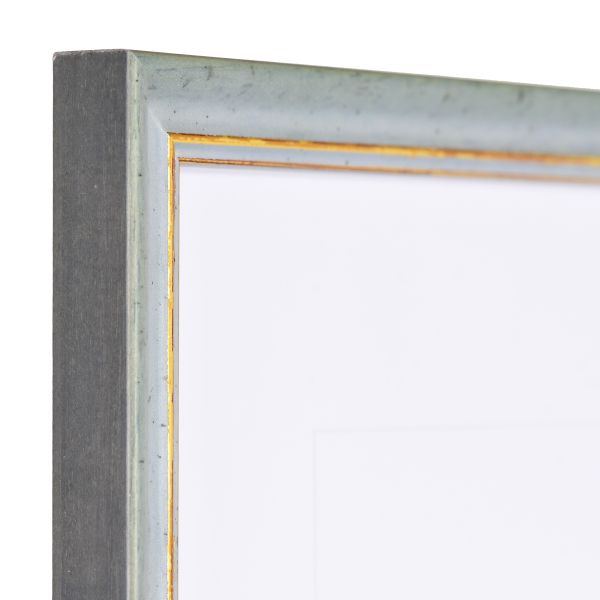 Vista de la esquina de un marco de madera vintage azul con superficie ligeramente rugosa y borde decorativo dorado