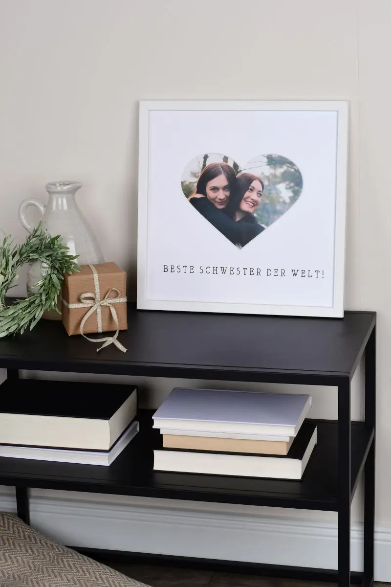 Marco de fotos 30x30 en blanco con un recorte de corazón para la mejor hermana del mundo en un ambiente de hogar