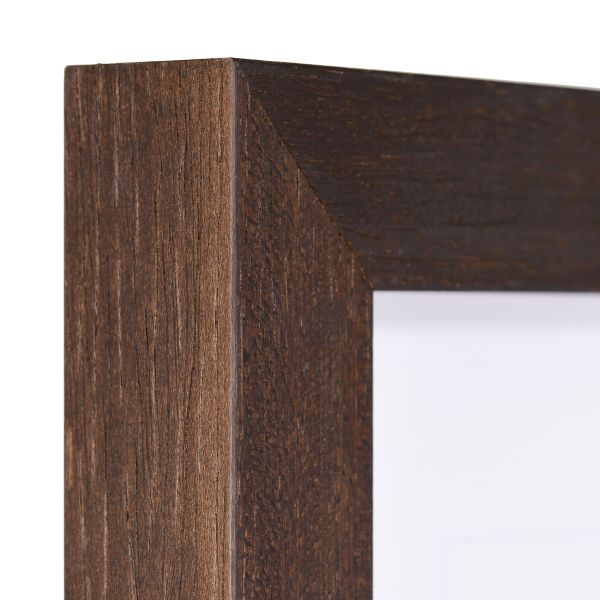 Vista de la esquina de un marco de madera marrón oscuro, lacado de poro abierto con una estructura de madera visible y táctil