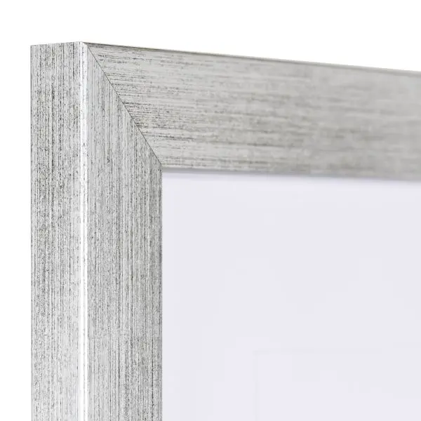 Vista de la esquina de un marco de fotos plateado con estructura de madera visible, superficie lisa y perfil angular y sencillo.
