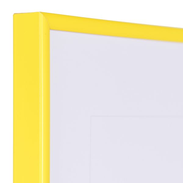 Vista de la esquina de un marco de plástico amarillo y estrecho con perfil semirredondo