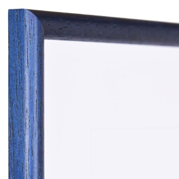Vista de la esquina de un marco de madera azul clásico, de poro abierto, con un perfil semicircular estrecho