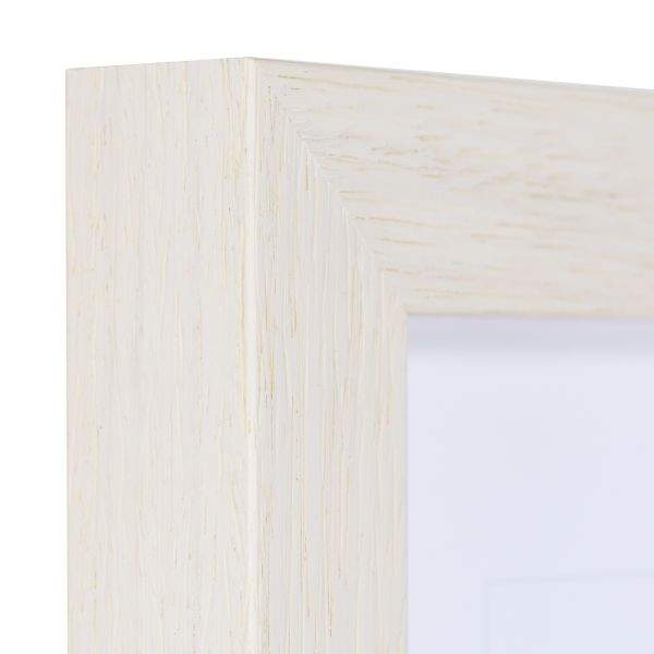 Vista de la esquina de un marco de madera blanco, lacado de poro abierto con la veta de la madera visible y táctil.