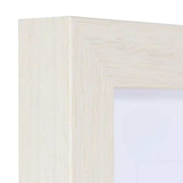Vista de la esquina de un marco de madera blanco, lacado de poro abierto con la veta de la madera visible y táctil.
