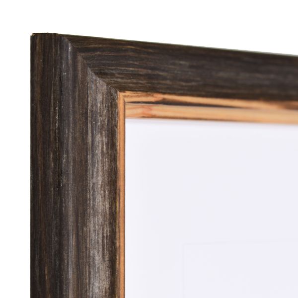 Vista de la esquina de un marco de madera marrón oscuro con un perfil de madera maciza sutilmente curvado y un borde interior rebajado al estilo rústico.