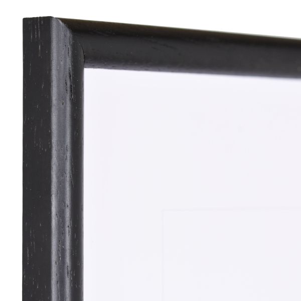 Vista de la esquina de un marco de madera negro clásico, de poro abierto, con perfil semicircular estrecho