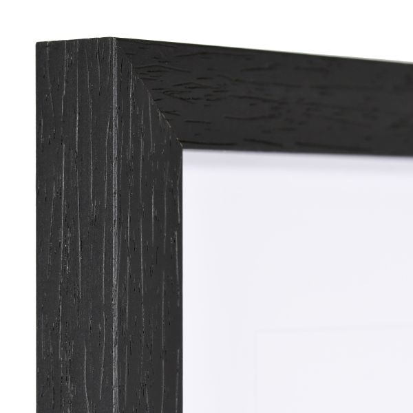 Vista de la esquina de un marco de madera cuadrado, moderno y negro, cuya estructura de madera es visible.