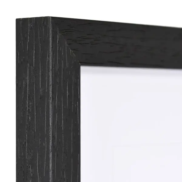 Vista de la esquina de un marco de madera cuadrado, moderno y negro, cuya estructura de madera es visible.