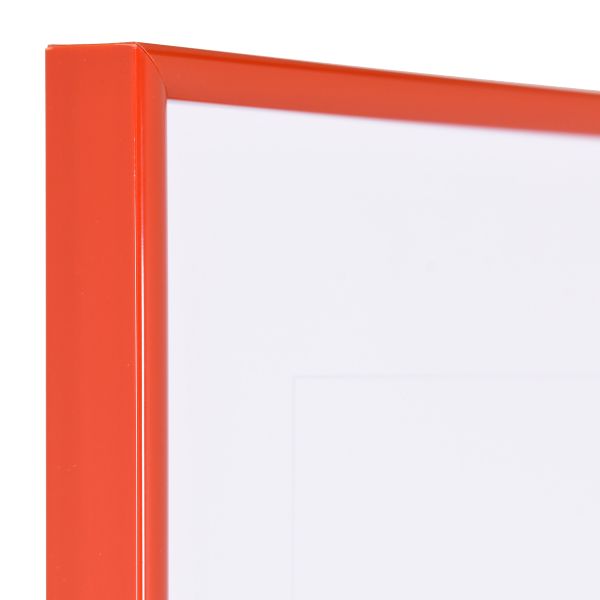 Vista de la esquina de un marco de plástico rojo, estrecho, con perfil semirredondo