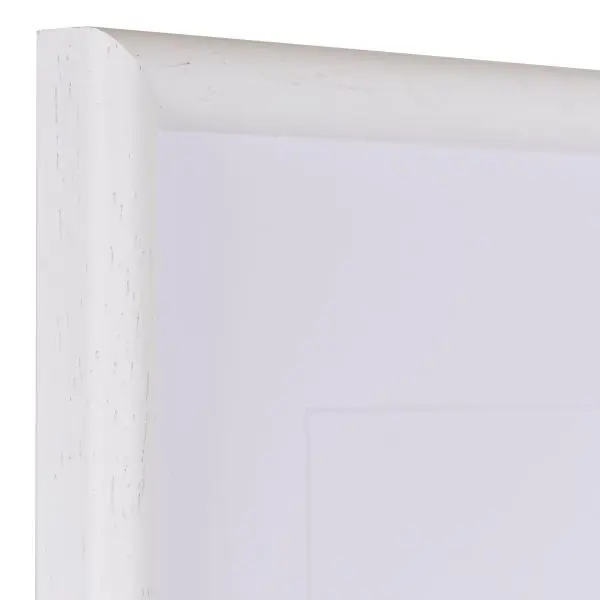 Vista de la esquina de un marco de madera blanco clásico, de poro abierto, con perfil semicircular estrecho.