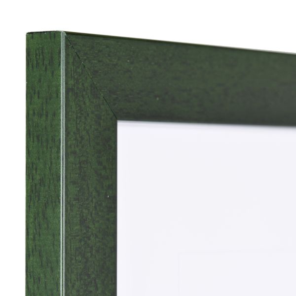 Vista de la esquina de un marco de fotos verde abeto con estructura de madera visible, superficie lisa y perfil angular y sencillo.