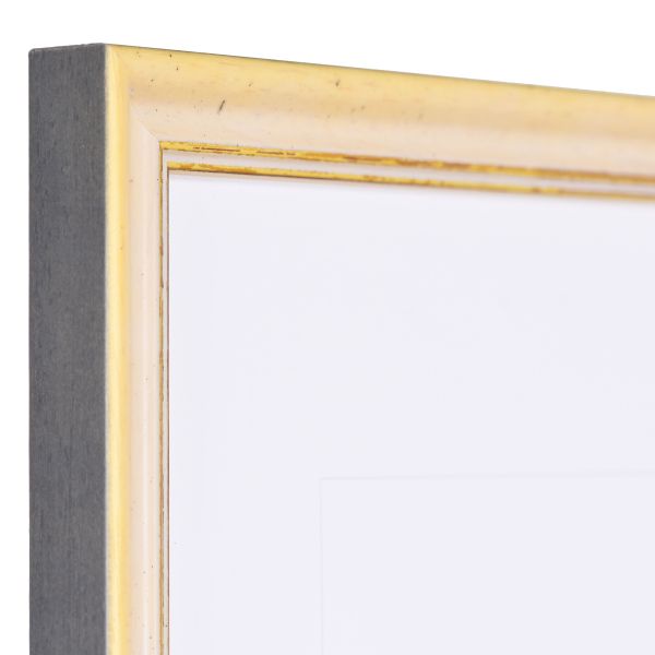 Vista de la esquina de un marco de madera Shabby Chic amarillo con superficie ligeramente rugosa y borde decorativo dorado.