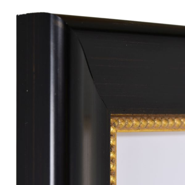 Vista de la esquina de un marco de fotos clásico negro con ribete de perlas dorado