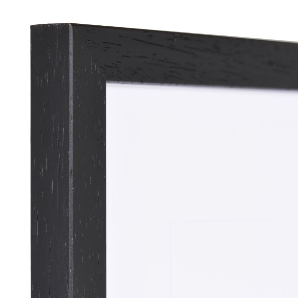 Vista de la esquina de un marco de madera negro con estructura de madera visible y borde estrecho