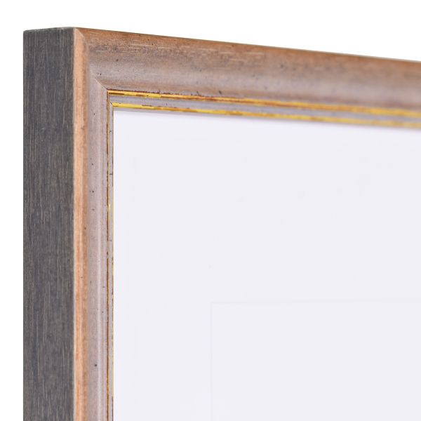 Vista de la esquina de un marco de madera vintage marrón con una superficie ligeramente rugosa y un borde decorativo dorado.